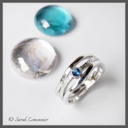 Bague artisanale en argent représenant 3 vagues avec ajourement et gravure et ornée d une topaze bleue